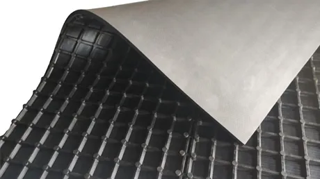 Imagem de um estrado isolante em formato de rolo, com uma camada externa que parece ser de material resistente e uma superfície interna com uma estrutura em grade ou rede. O estrado é usado para fornecer isolamento térmico, acústico ou elétrico em diversas aplicações industriais, construção civil ou transporte.

